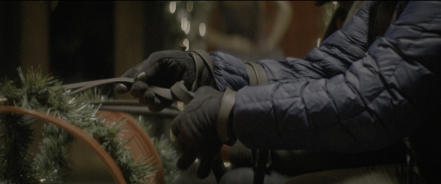 Wide shot frame from The Night Before — sitting, table, hand