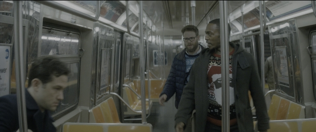 Wide shot frame from The Night Before — sitting, walking, train
