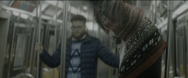 Wide shot frame from The Night Before — standing, face, train
