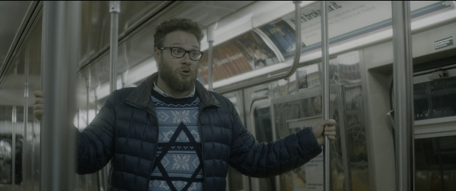 Wide shot frame from The Night Before — standing, jacket, beard