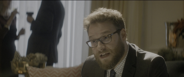 Wide shot frame from The Night Before — sitting, room, suit