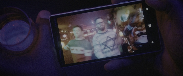 Wide shot frame from The Night Before — standing, phone, hand
