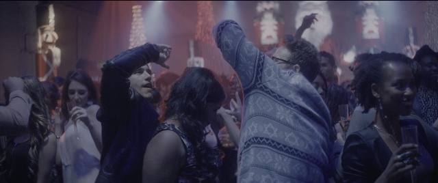 Wide shot frame from The Night Before — hand, dress, shirt