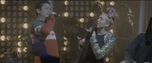 Wide shot frame from The Night Before — standing, dress, face