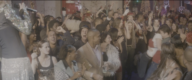 Wide shot frame from The Night Before — standing, room, suit