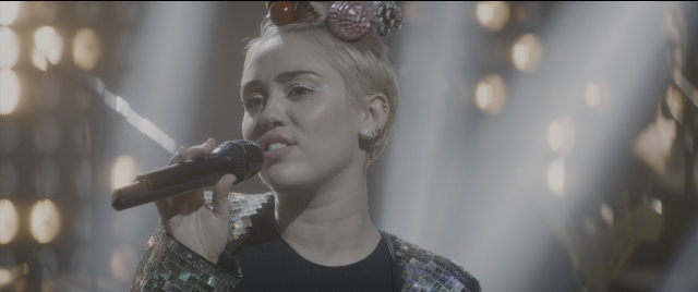 Wide shot frame from The Night Before — microphone, hair, person