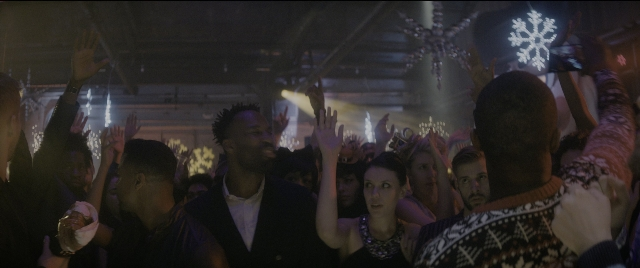 Wide shot frame from The Night Before — standing, room, suit