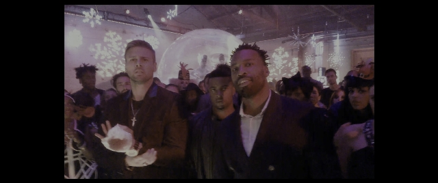 Wide shot frame from The Night Before — standing, room, hand