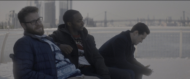 Wide shot frame from The Night Before — sitting, dialogue, phone
