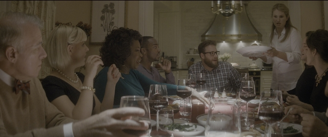 Wide shot frame from The Night Before — sitting, plate, table