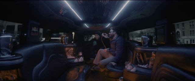 Wide shot frame from The Night Before — sitting, table, phone