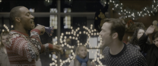 Wide shot frame from The Night Before — standing, table, hand