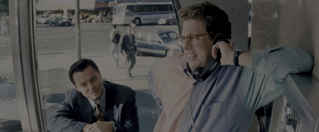 Wide shot frame from The Wolf of Wall Street — sitting, walking, dialogue