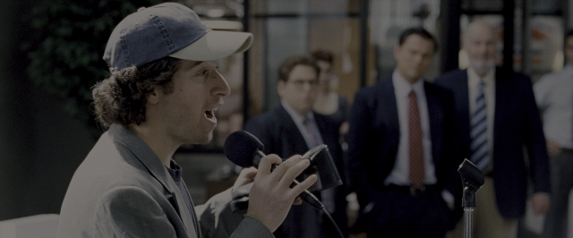 Wide shot frame from The Wolf of Wall Street — dialogue, hat, hand