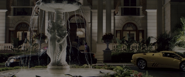 Wide shot frame from The Wolf of Wall Street — walking, street, car