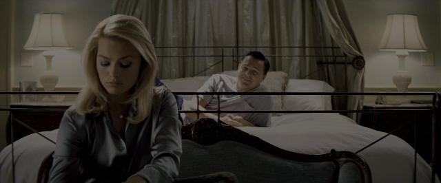 Wide shot frame from The Wolf of Wall Street — sitting, bed, bedroom