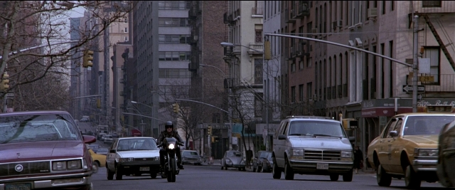 Wide shot frame from Black Rain — street, car, van