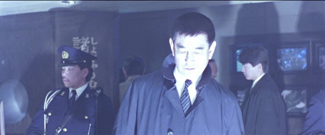 Wide shot frame from Black Rain — walking, hat, uniform