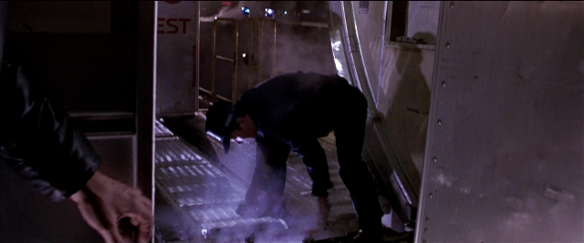 Wide shot frame from Black Rain — door, hat, hand