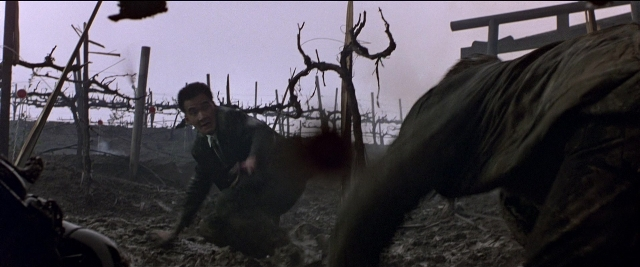 Wide shot frame from Black Rain — coat, hand, gun