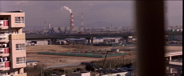 Frame from Black Rain — smoke, window, building