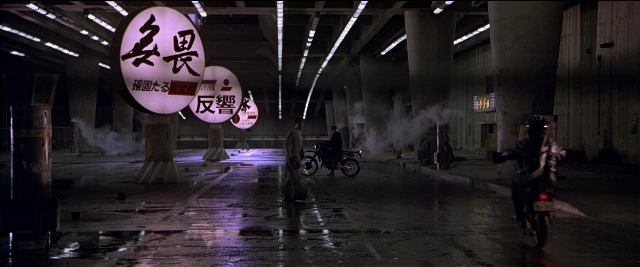 Wide shot frame from Black Rain — dialogue, bicycle, water