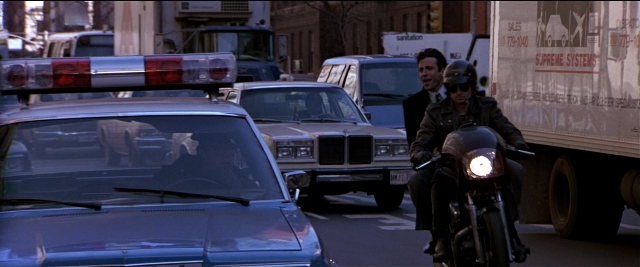Wide shot frame from Black Rain — dialogue, street, hat