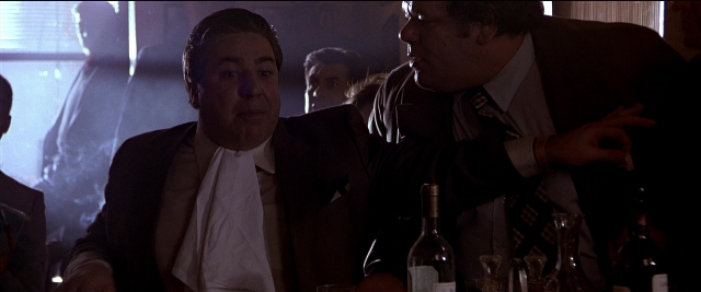 Wide shot frame from Black Rain — sitting, room, table