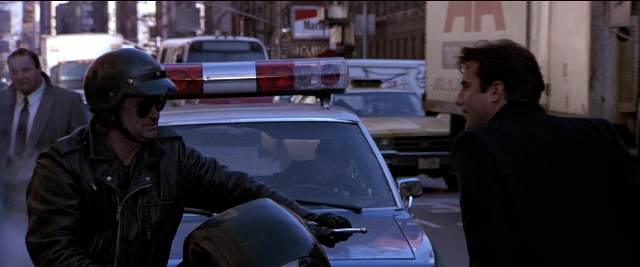 Wide shot frame from Black Rain — sitting, standing, phone