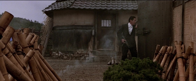 Wide shot frame from Black Rain — standing, hand, suit