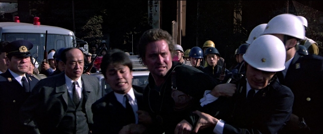Wide shot frame from Black Rain — dialogue, street, suit