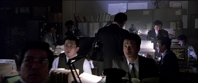 Medium shot frame from Black Rain — sitting, room, office