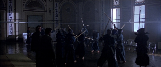 Wide shot frame from Black Rain — standing, room, fight