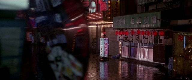 Wide shot frame from Black Rain — street, night, building