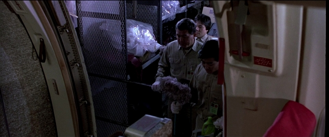 Wide shot frame from Black Rain — room, door, bottle