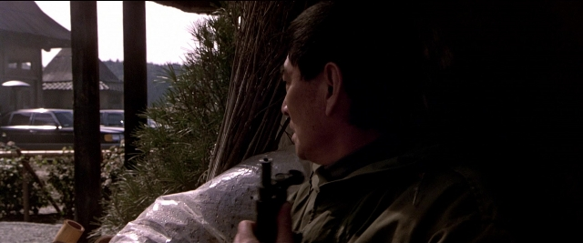 Wide shot frame from Black Rain — standing, car, hand