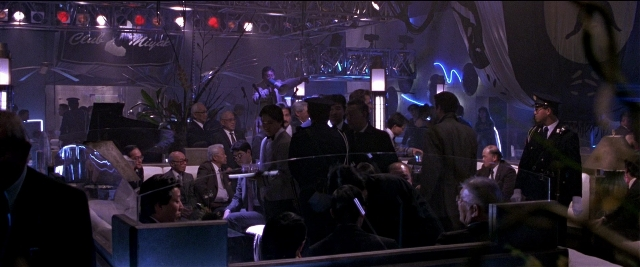 Wide shot frame from Black Rain — sitting, standing, room