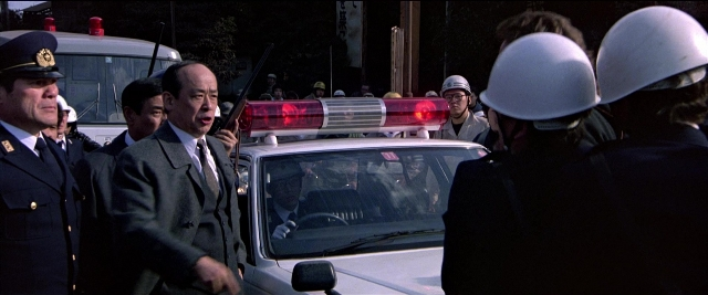 Wide shot frame from Black Rain — dialogue, street, uniform