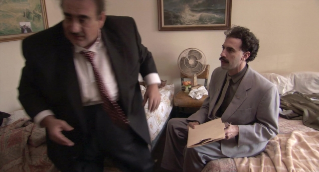 Wide shot frame from Borat: Cultural Learnings of America for Make Benefit Glorious Nation of Kazakhstan — sitting, standing, room