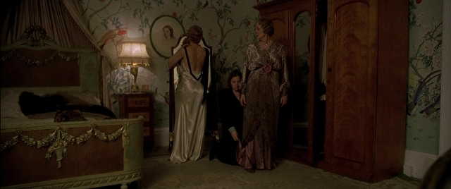 Wide shot frame from Gosford Park — standing, room, bed