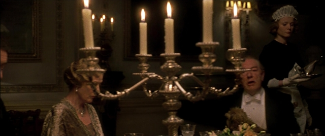 Wide shot frame from Gosford Park — sitting, book, table