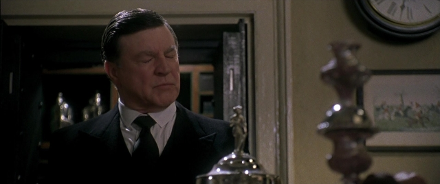Wide shot frame from Gosford Park — standing, room, suit