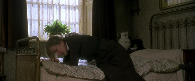 Wide shot frame from Gosford Park — room, bed, suit