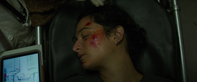 Wide shot frame from Hotel Artemis — bed, face, person