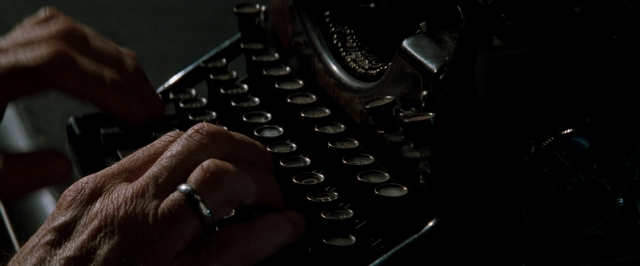 Frame from In the Mouth of Madness — room, person, office supplies