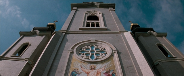 Wide shot frame from In the Mouth of Madness — tower, glass, window