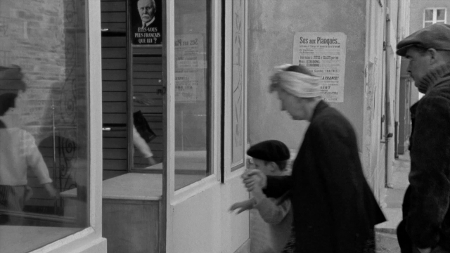 Wide shot frame from In the Mouth of Madness — people, action, show