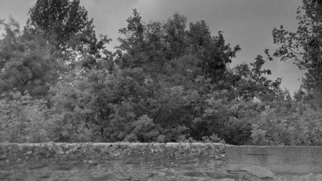 Frame from In the Mouth of Madness — people, sitting, action