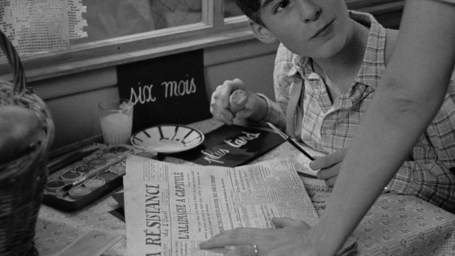 Wide shot frame from In the Mouth of Madness — people, sitting, read
