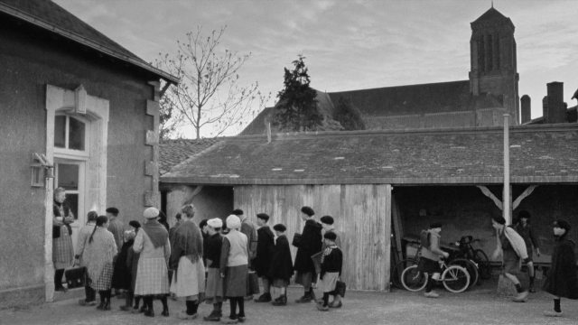 Wide shot frame from In the Mouth of Madness — standing, house, bicycle